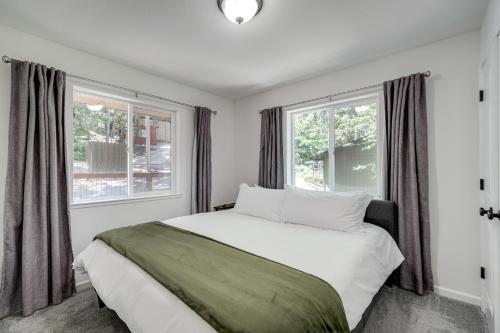 a bedroom with a large bed and two windows at Walk to Dtwn Charming Family Cabin in Twain Harte in Twain Harte
