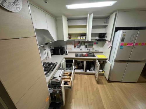 a kitchen with white cabinets and a stainless steel refrigerator at AwesomeSuwon 주재원 장기거주 할인 in Suwon