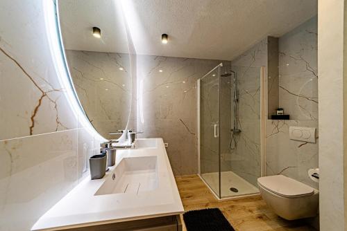 a bathroom with a sink and a toilet and a mirror at ŽIŽULA Rooms in Vela Luka