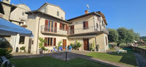 a large white house with a yard with chairs at la casa dell'uva in Monte Isola
