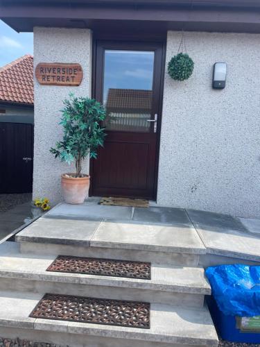 a front door of a house with a bunch of bees at Riverside Retreat in Caol