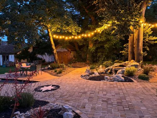 a garden with a patio with lights and a stone path at Château Ségot in Neuilly-le-Réal