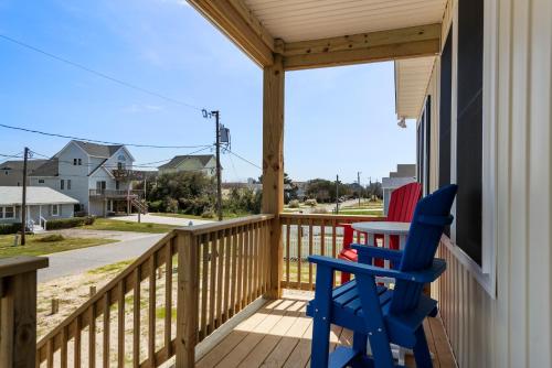 a porch with two blue chairs and a table at Coles Cabana in Kill Devil Hills