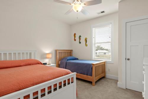 a bedroom with a bed and a ceiling fan at Coles Cabana in Kill Devil Hills