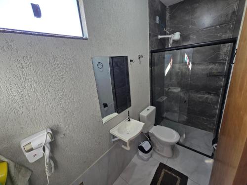 a bathroom with a toilet and a sink and a shower at Flat completo a 21 minutos da BR-153 in Aparecida de Goiania