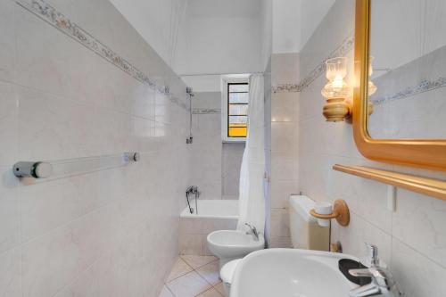 Un baño blanco con inodoro y lavabo. en flat pet friendly free wifi inalpi arena olimpico metro, en Turín