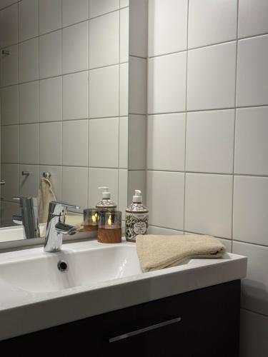 a bathroom sink with a towel and a mirror at Geiloholtet central city apartment in Geilo