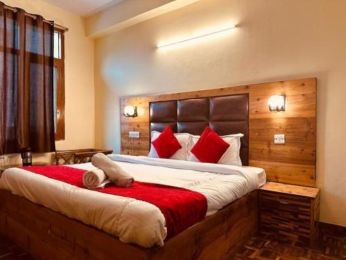 a bedroom with a large bed with red pillows at Hotel Mist Bhimtal in Bhīm Tāl