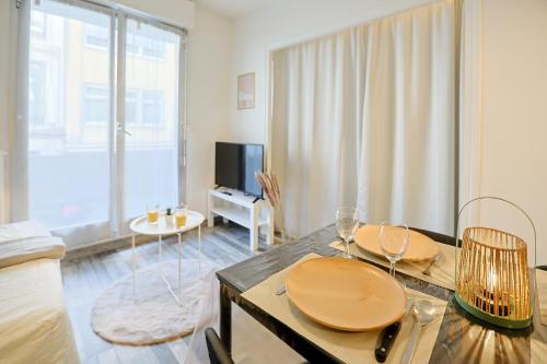 a living room with a dining table with wine glasses at La Terrasse Douillette - Pl Jean Jaurès - Terrasse in Saint-Étienne