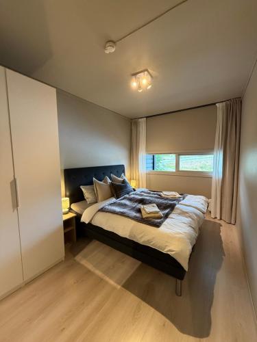 a bedroom with a large bed and a window at Geiloholtet central city apartment in Geilo