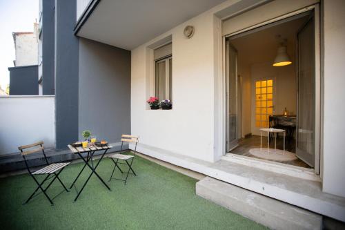 Un balcón con una mesa y sillas en un edificio. en La Terrasse Douillette, en Saint-Étienne