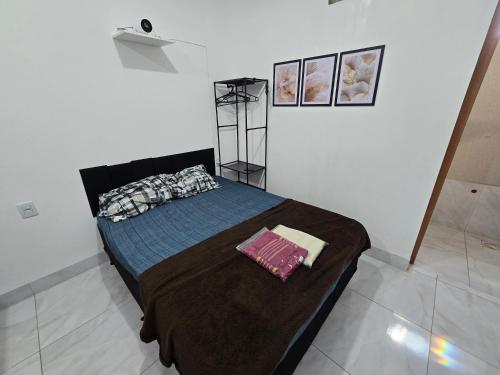 a bedroom with a bed in a white room at Flat completo a 19 minutos do Buriti Shopping in Aparecida de Goiania