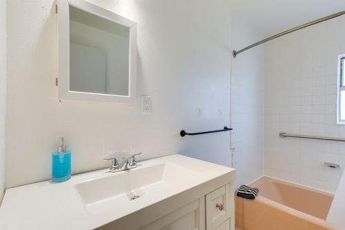 a bathroom with a sink and a mirror and a tub at Entire Home 3 bds 2 bats in Seattle
