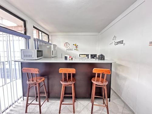 a kitchen with two wooden stools at a counter at Suite#11 Cerca de Auto. Mex-Qro. in Cuautitlán Izcalli