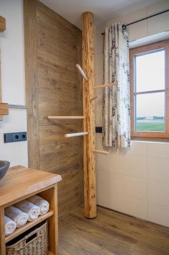 a kitchen with a wooden wall with a window at Stadlerhof Alpen- & Seeblick in Kirchanschöring
