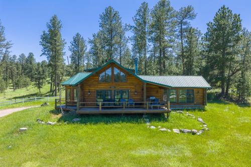 a log cabin in the middle of a field at Whitetail Springs Ranch in Custer