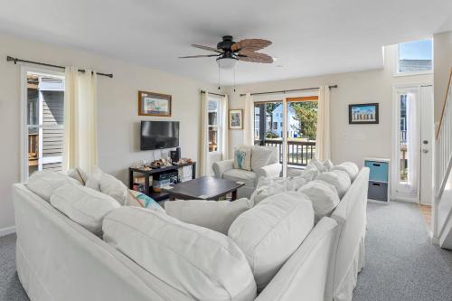 a living room with white furniture and a ceiling fan at Corolla & Lime in Corolla