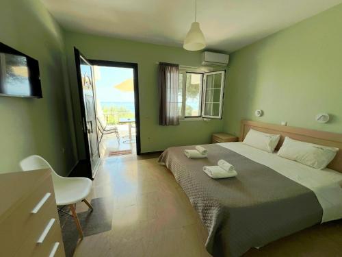a bedroom with a large bed and a balcony at Nissaki Bay in Nisakion