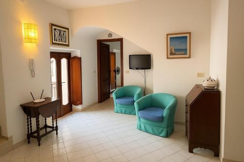 a living room with two chairs and a television at Dream View in Positano in Positano