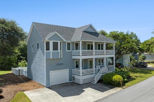 a large blue house with a garage at Country Roads in Corolla