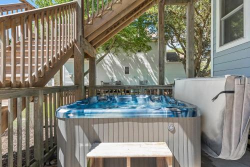 a hot tub on a deck next to a house at Country Roads in Corolla