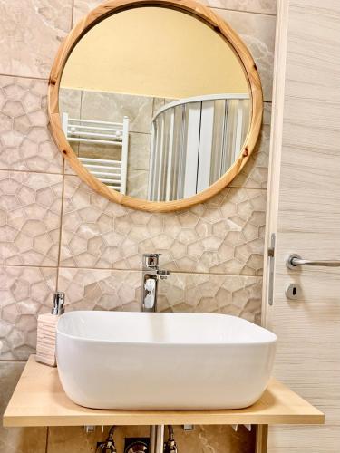 a bathroom with a white sink and a mirror at La Libellula - via Diaz 34 in Galatro