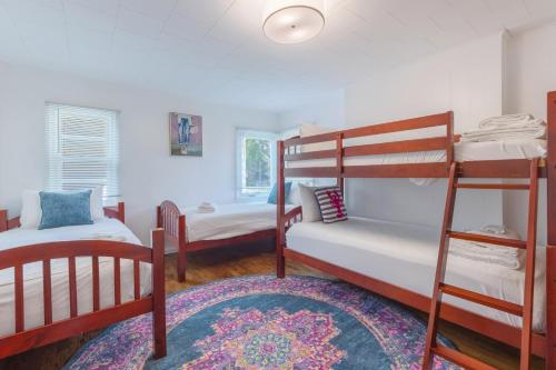 a bedroom with two bunk beds and a rug at Relaxation Station - Hot tub and scenic location downtown South Haven in South Haven