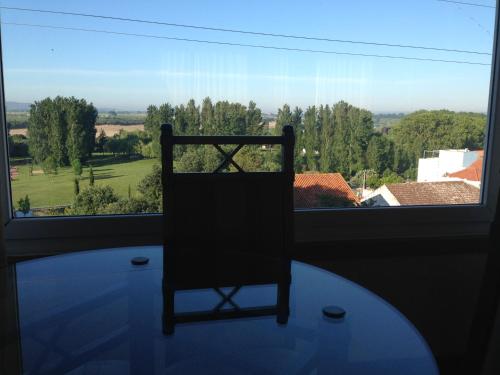 a chair sitting in front of a large window at Soltejo in Vila Nova da Barquinha