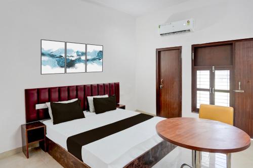 a bedroom with a bed and a wooden table at Hotel O Star Key Inn in Sohna