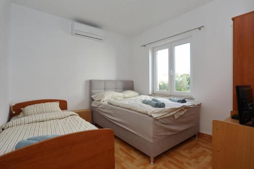 ペトルチャネにあるMare 9 Cozy Two Bedroom Apartment with Gardenの窓のある部屋にベッドが2つある