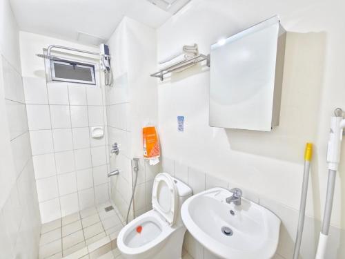 a white bathroom with a toilet and a sink at Home in Manila Breathtaking Sunset View in Manila