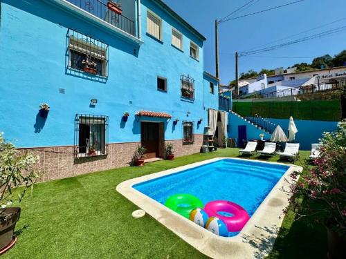a blue house with a swimming pool in the yard at La casa de mis padres in Júzcar