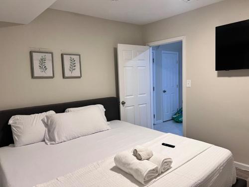 Haven 2 Bedroom by EWR airport في نيوآرك: غرفة نوم بسرير ابيض عليها مناشف