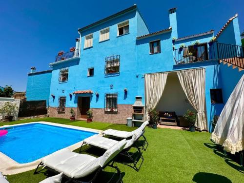 a blue house with a swimming pool in front of it at La casa de mis padres in Júzcar