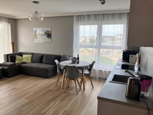 ein Wohnzimmer mit Sofa und Tisch in der Unterkunft Apartament MioMare, Basen, Parking in Kołobrzeg