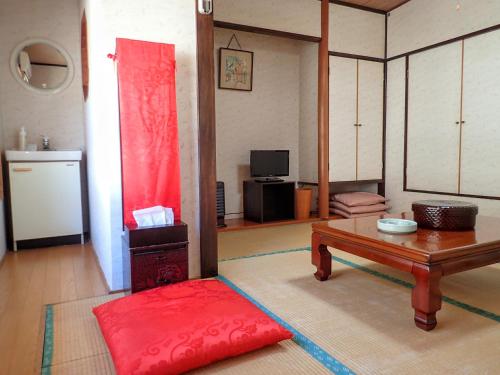 a living room with a table and a red rug at Oyado Matsubaya in Minakami