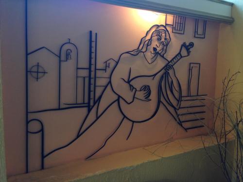 a mural of a man playing a guitar on a wall at Soltejo in Vila Nova da Barquinha