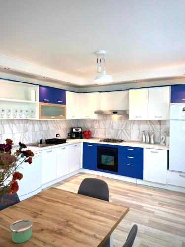 a kitchen with blue and white cabinets and a wooden table at Vivien Chalet in Victoria