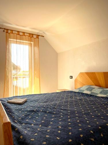 a bedroom with a bed with a blue blanket and a window at Vivien Chalet in Victoria