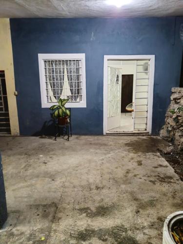 an empty room with a blue wall and a door at Casa Mango Confort in Mérida