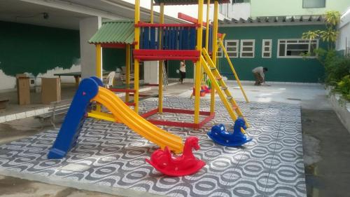 a playground with a slide and toys on a carpet at Apartamento na Praia do Forte - Cabo Frio in Cabo Frio