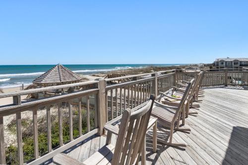 una fila di sedie sedute su una passerella vicino alla spiaggia di DE03- Anchors Away a Nags Head