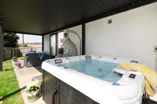 a hot tub in the backyard of a house at Sandy Cove in Penzance