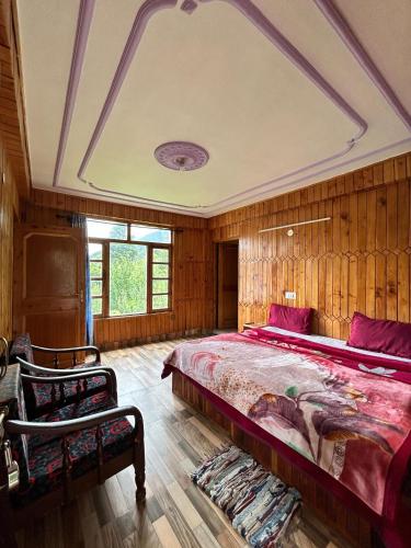 a bedroom with a large bed and wooden walls at The essence of mountains - מהות ההרים in Manāli