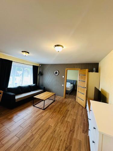 a living room with a couch and a table at Rožu namu apartamenti 4 in Kuldīga