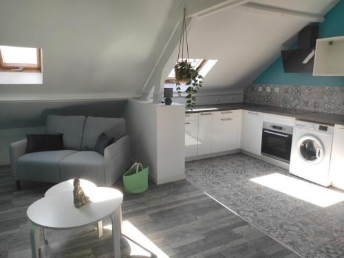 a living room with a couch a table and a microwave at Loftissime in Dunkerque