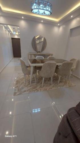 a dining room with a table and chairs and a mirror at Eamar tower 2 in Tanta