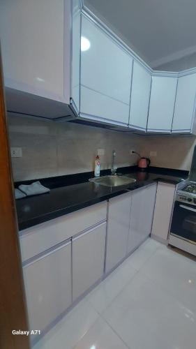 a kitchen with white cabinets and a sink at Eamar tower 2 in Tanta