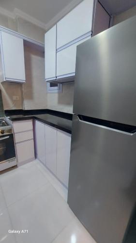 a kitchen with white cabinets and a stainless steel refrigerator at Eamar tower 2 in Tanta