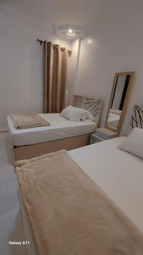 a room with two beds and a mirror at Eamar tower 2 in Tanta